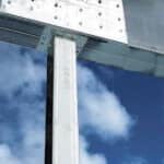Image of a Metwood Trimmable SQUARE COLUMN™ supporting a steel girder with a beautiful clear blue sky in the background.