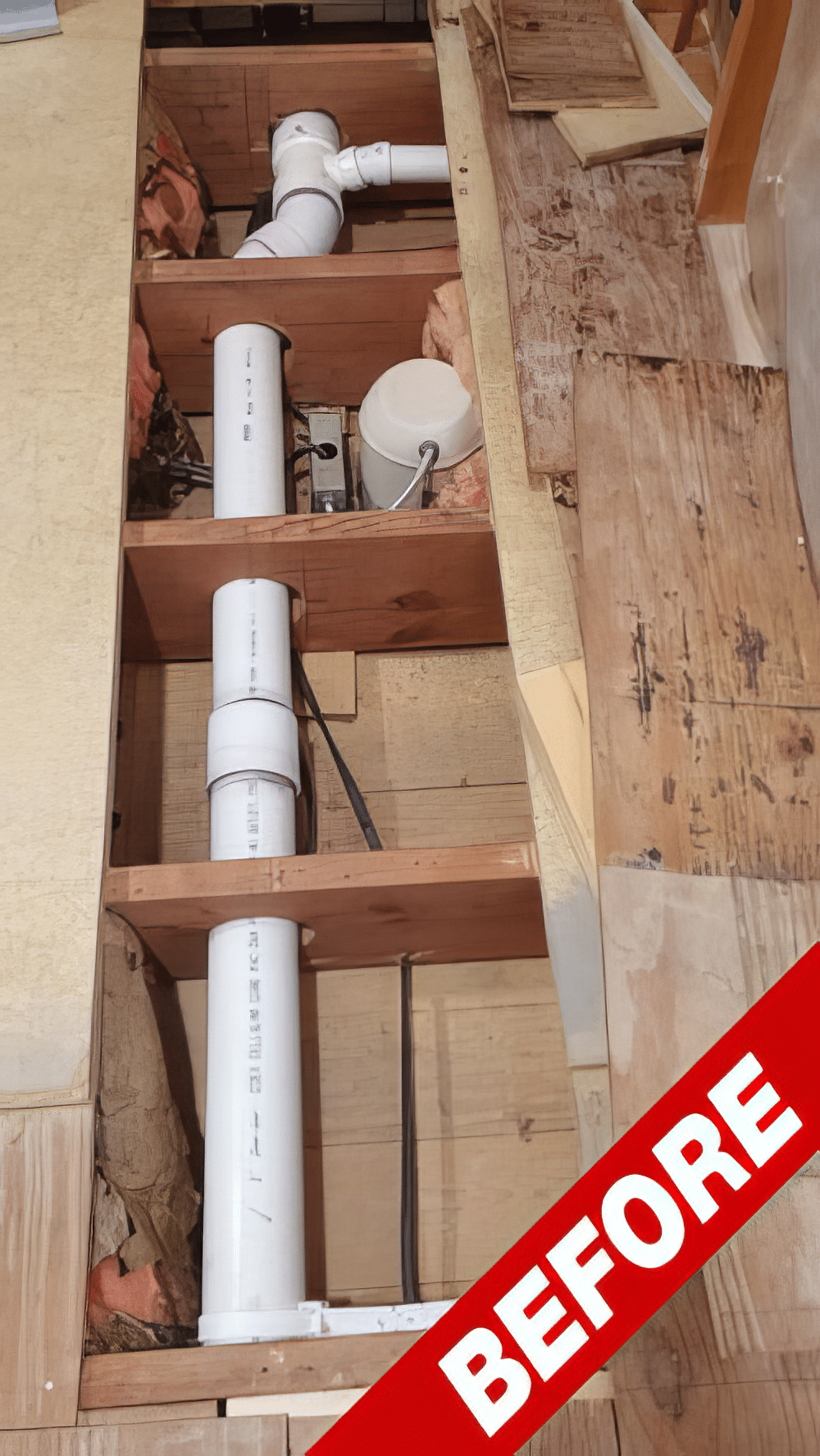 Before: oversized PVC plumbing holes cut through floor joists, unreinforced
